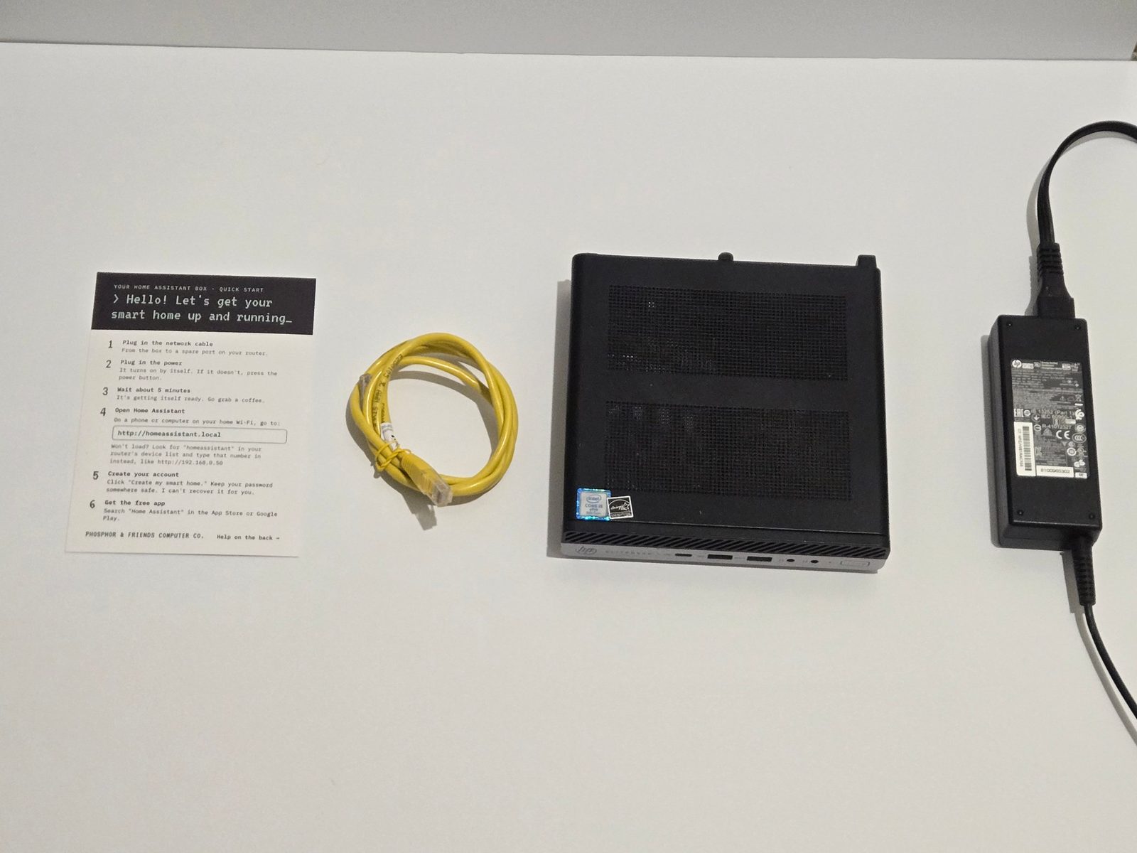 Everything included with the box: quick-start card, yellow ethernet cable, mini PC and power adapter