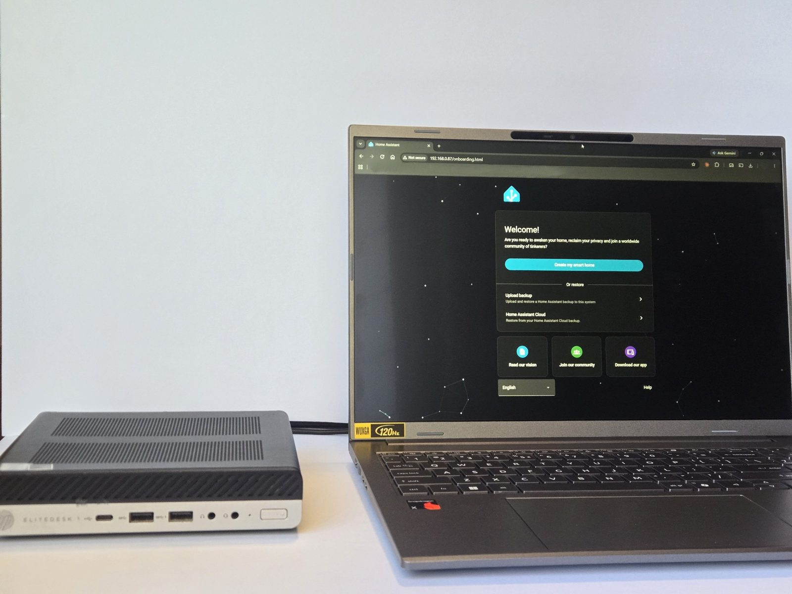Home Assistant box next to a laptop showing the Home Assistant welcome screen